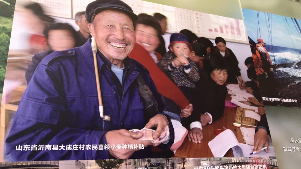 Sur une affiche, des paysans reçoivent des subventions pour la culture du blé en Chine.