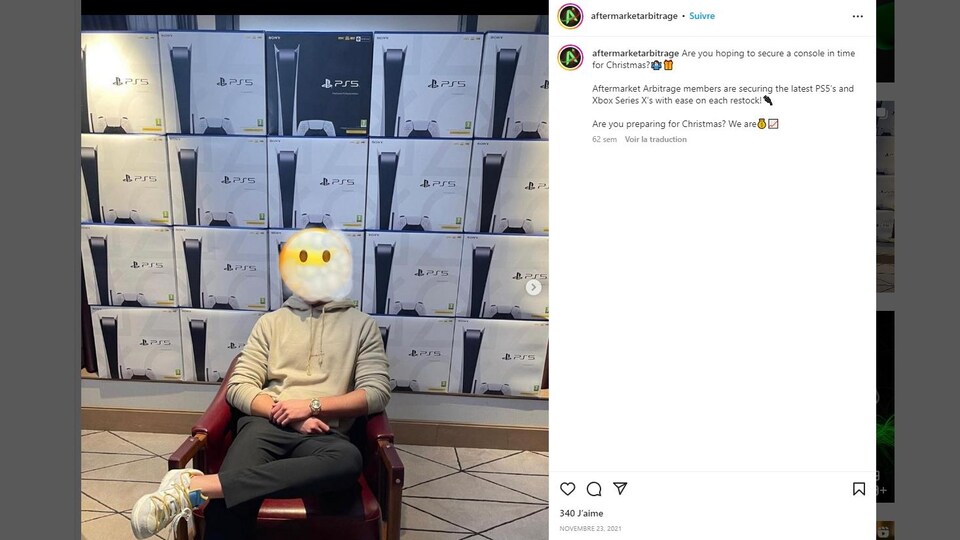 Un homme dont le visage est caché pose devant des boîtes de consoles de jeux vidéo.