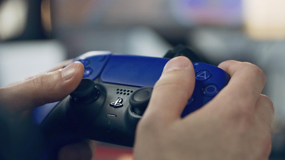 Une manette de PlayStation 5 bleue et noire.
