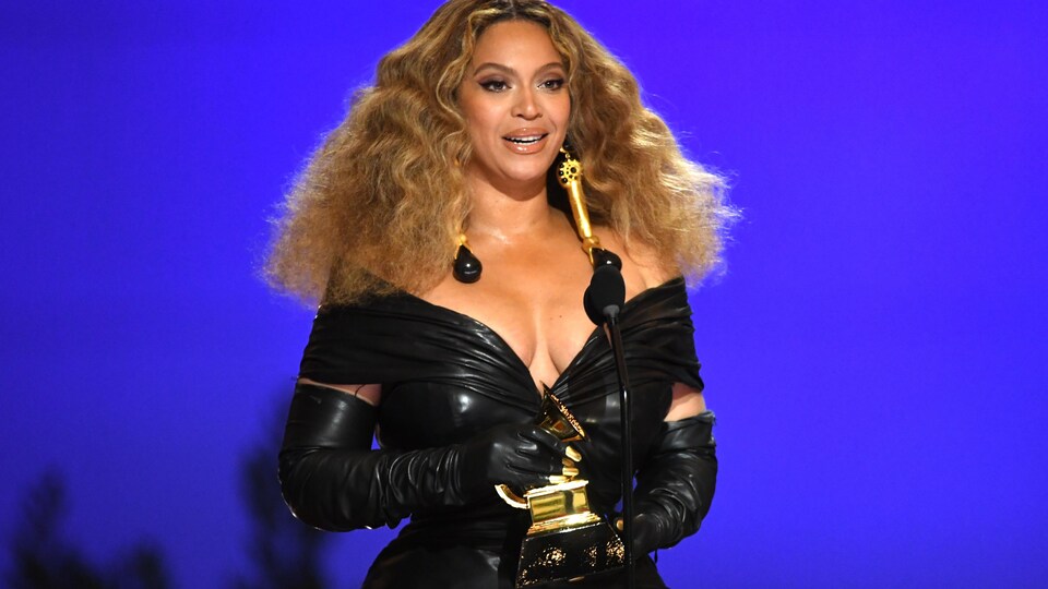 Beyoncé sur scène tenant un trophée. 