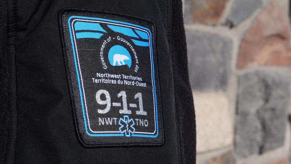 Le logo du service 911 sur la manche d'un manteau.