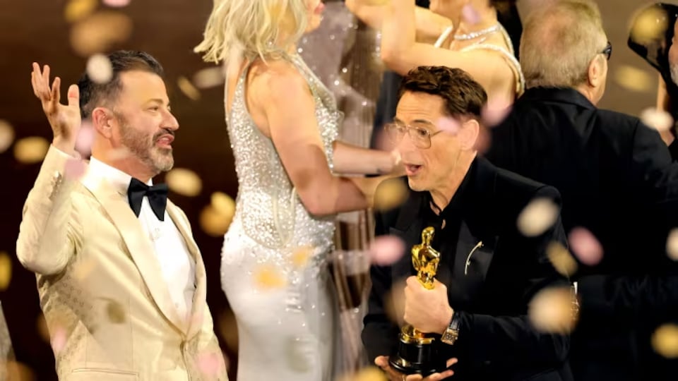 L'acteur Robert Downey Jr. accepte un prix Oscar à côté de l'animateur Jimmy Kimmel.
