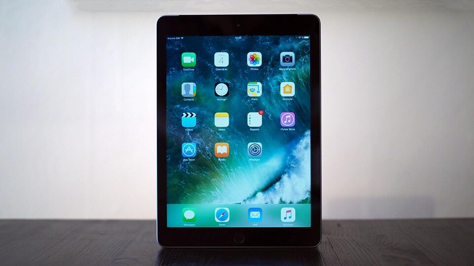Le nouvel iPad de 9,7 pouces (2017) avec l'écran allumé qui affiche les icônes des applications.