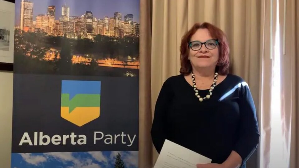 Jacquie Fenske, devant une affiche du Parti albertain.