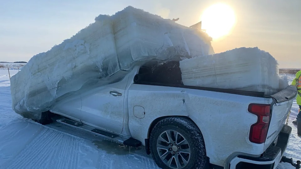 Un camion blanc dont l'habitacle est pris dans un cube de glace.
