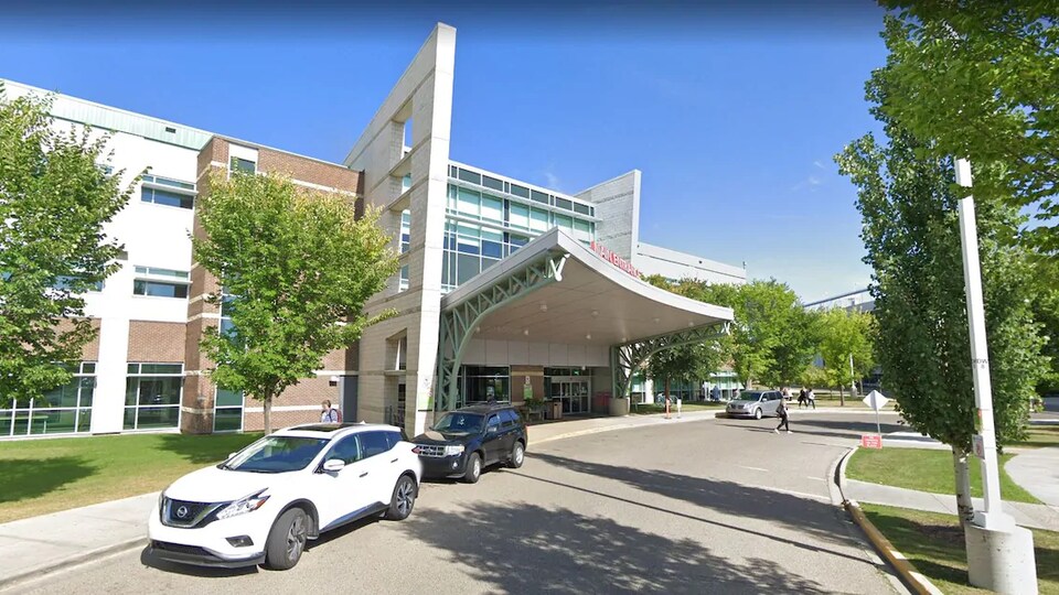 La façade de l'hôpital de Red Deer, devant lequel sont stationnés des véhicules.