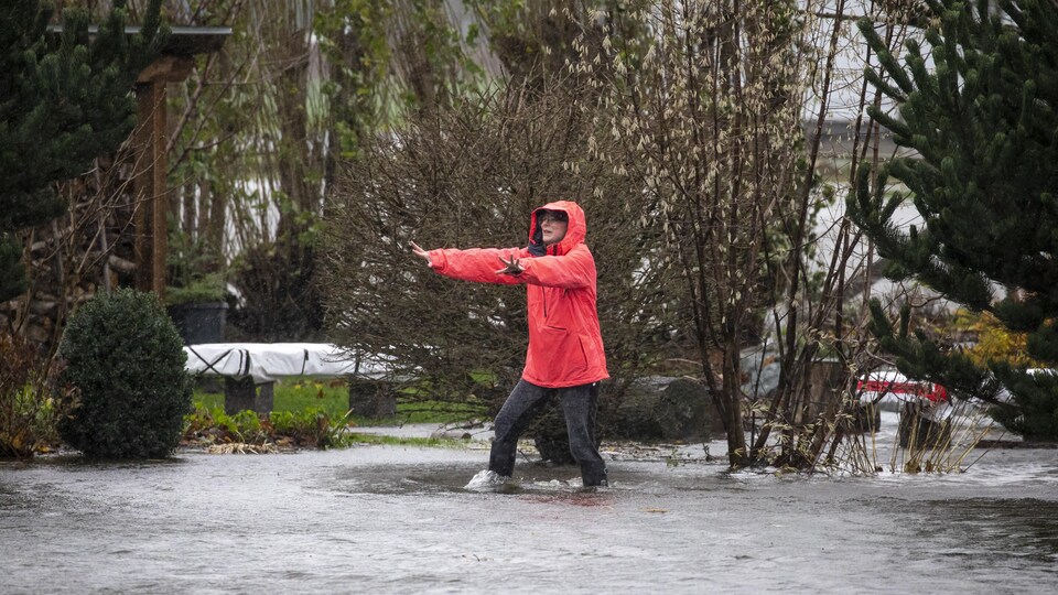 Une femme fuit l'inondation à Abbotsford, en Colombie-Britannique.
