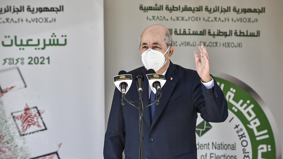Le président algérien Abdelmadjid Tebboune, portant un masque de protection, s'adresse aux médias.