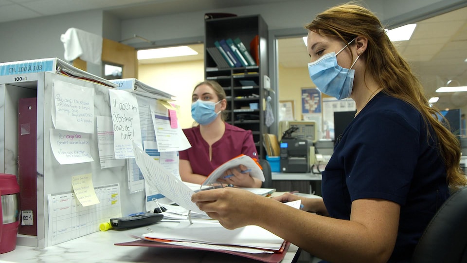 Deux infirmières consultent leurs dossiers.