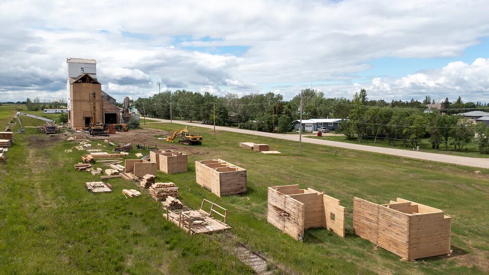 Des tas de bois éparpillés sur un terrain après avoir été retirés d'un élévateur à grain.
