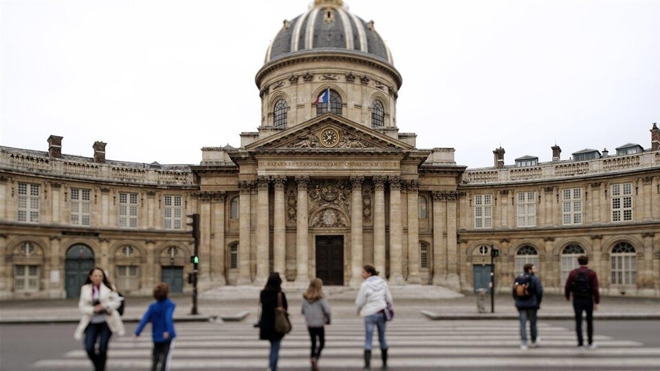 Des gens circulent devant l'Académie française, à Paris