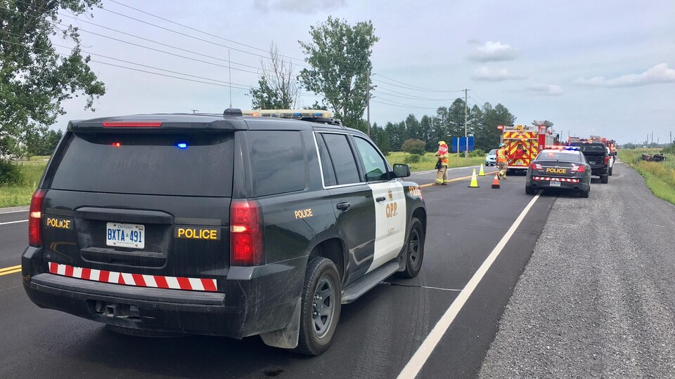 Des voitures de la Police provinciale de l'Ontario et un camion de pompiers sur les lieux d'un accident.