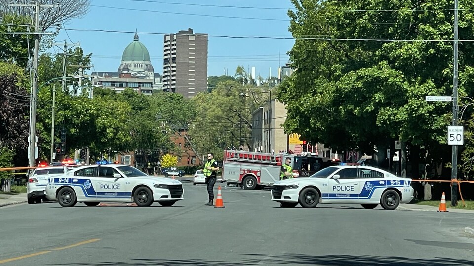 Un ruban délimite une scène d'accident. Des autopatrouilles du SPVM protègent la scène.