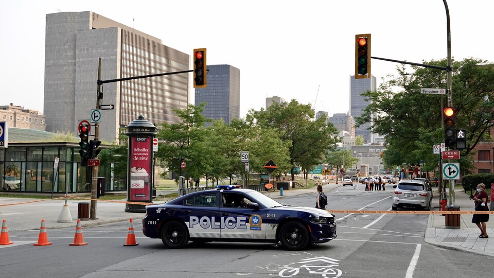 Une rue bloquée par un véhicule de police au centre-ville de Montréal.