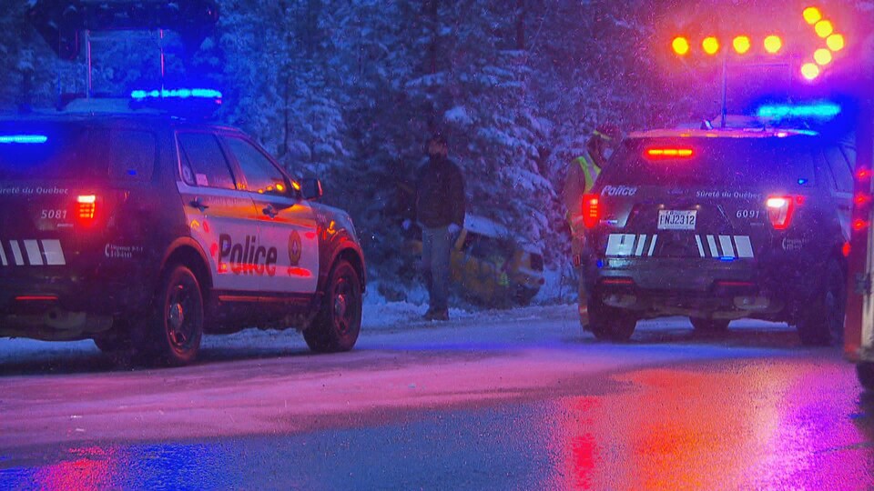 Une voiture sortie de la route est entourée de véhicules de police.