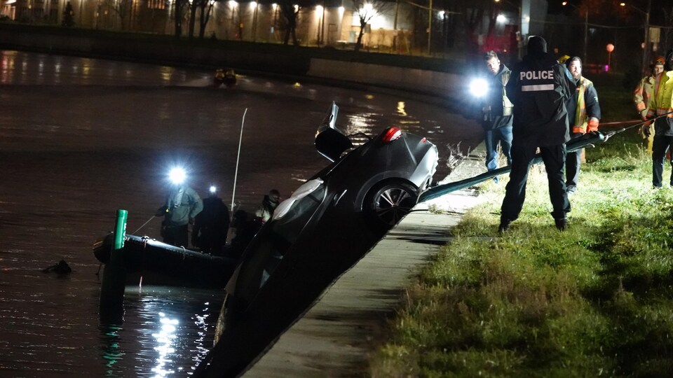 Des policiers sortent une voiture du canal Lachine. 