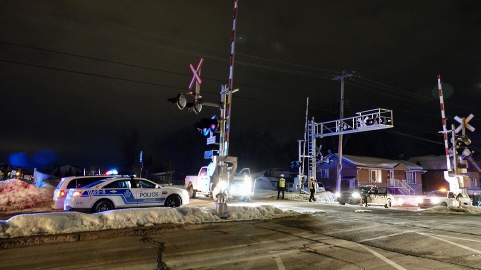 Des voitures de police au passage à niveaux.