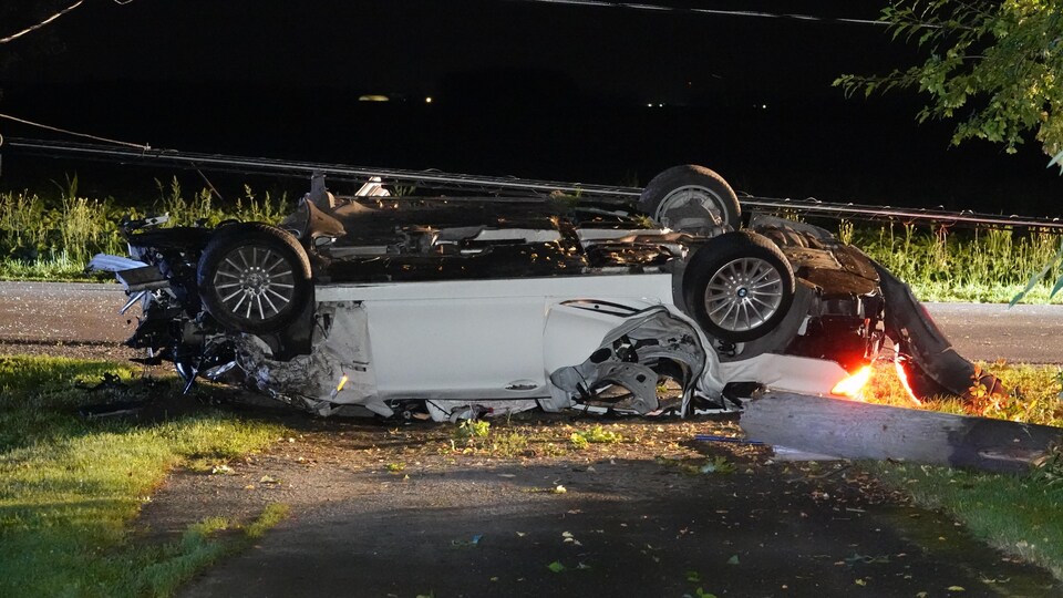 La voiture est renversée sur le toit.