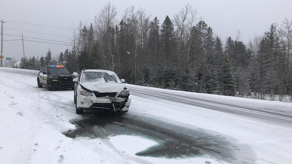 Un véhicule accidenté sur une chaussée enneigée.