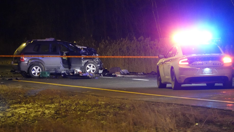 La voiture accidentée derrière un ruban de sécurité.