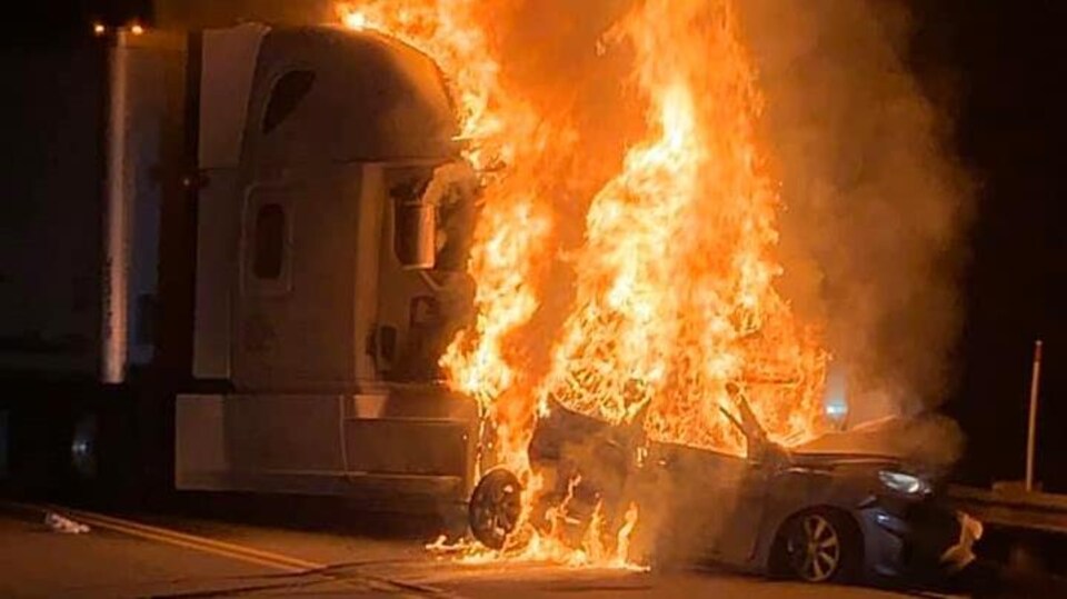 Une voiture en flammes et un camion poids lourd