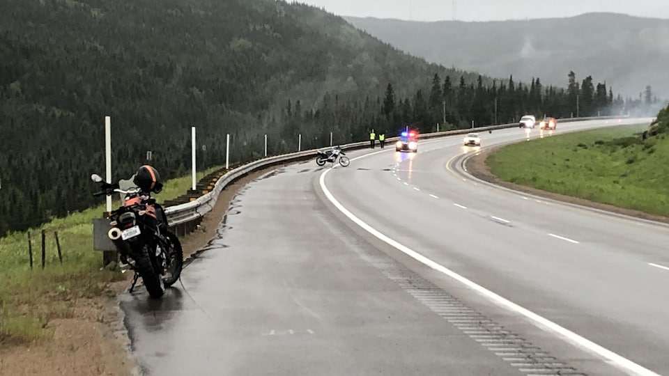 Deux motos et une voiture de police sur une route.