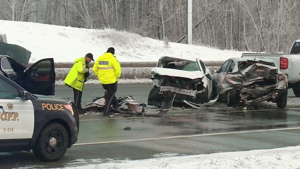 Des inspecteurs de la Police provinciale de l'Ontario inspectent les débris laissés par la collision.