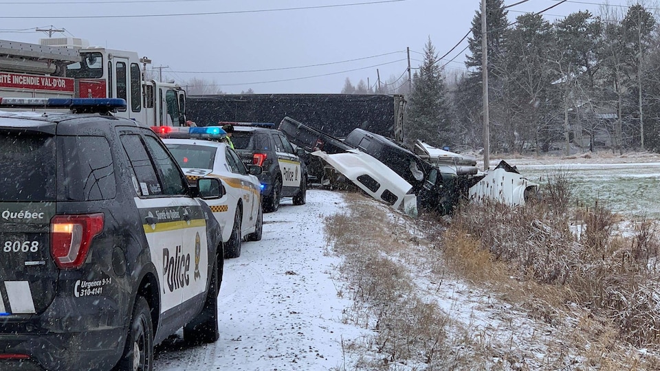 Une camionnette et un fardier dans un fossé sur le bord de la route.