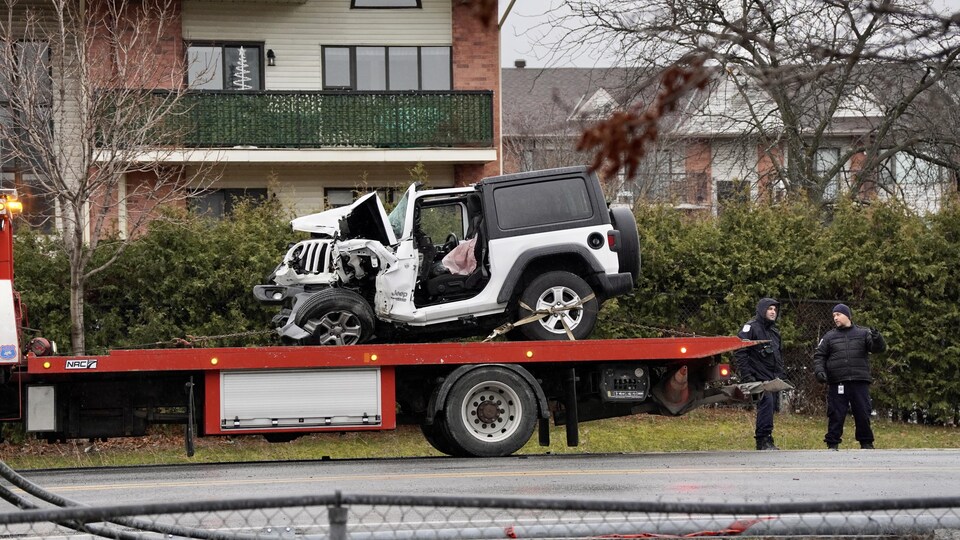 Un véhicule accidenté est porté par un camion plateau.                             