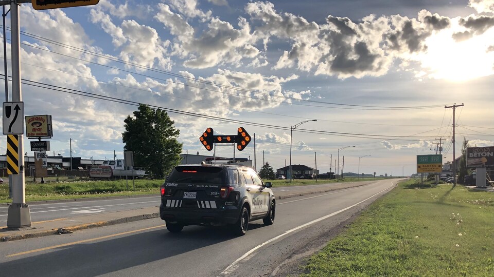 Une voiture de police bloque une rue.