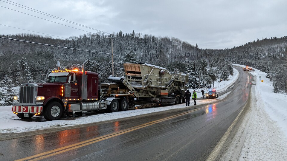 Un camion lourd stationné sur le côté d'une route en hiver.