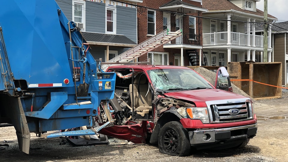Une scène d'accident entre un camion de poubelles et une camionnette.