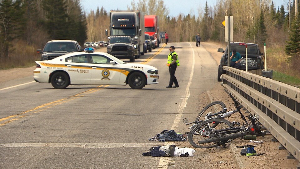 Un policier de la Sûreté du Québec contrôle la circulation sur une route où deux cyclistes ont été happés.