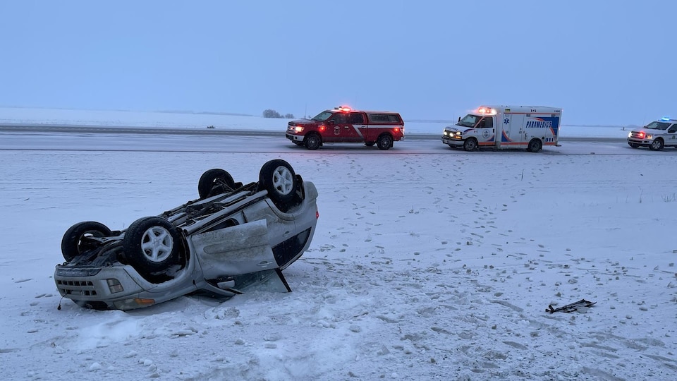 Une voiture est renversée après avoir glissé sur la chaussée verglacée dans la région de Warman, en Saskatchewan.