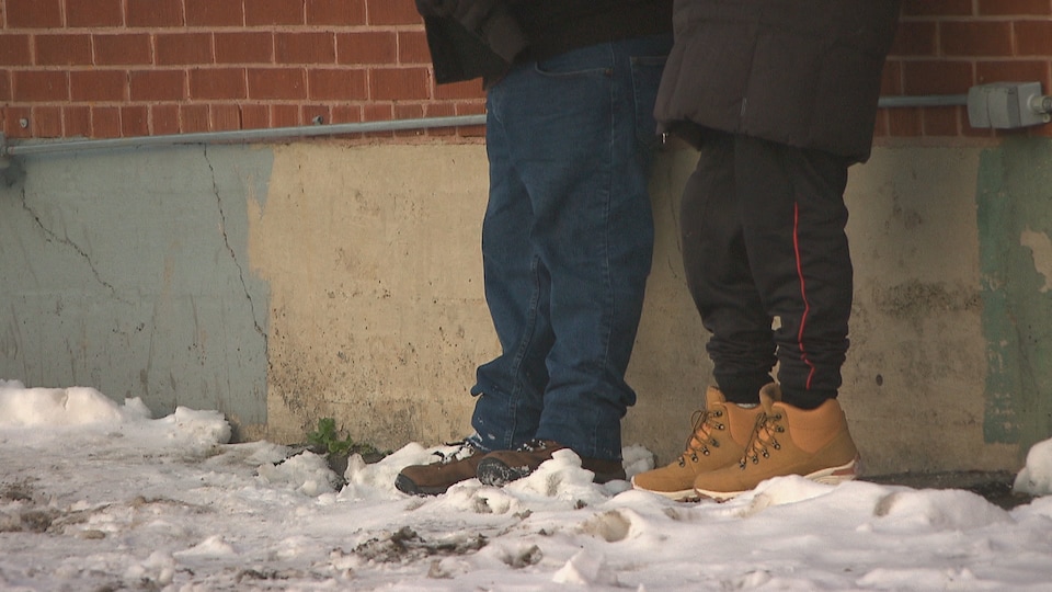 Les pieds de deux personnes dans la neige.