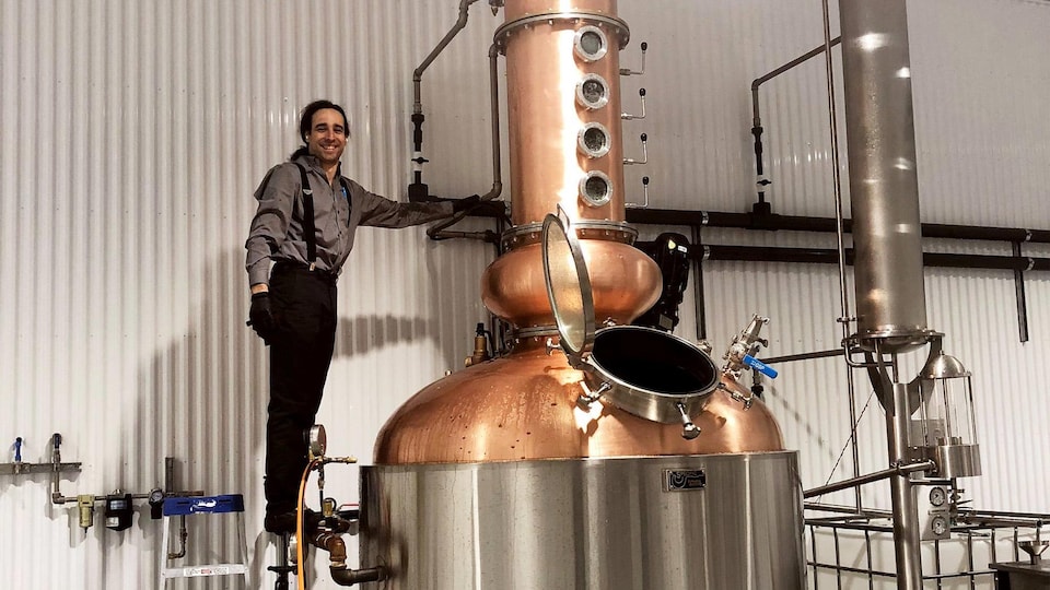 Michaël Fortin, directeur général de Distillerie Témiscouata, pose à côté d'un alambic de l'acerum de l'entreprise.