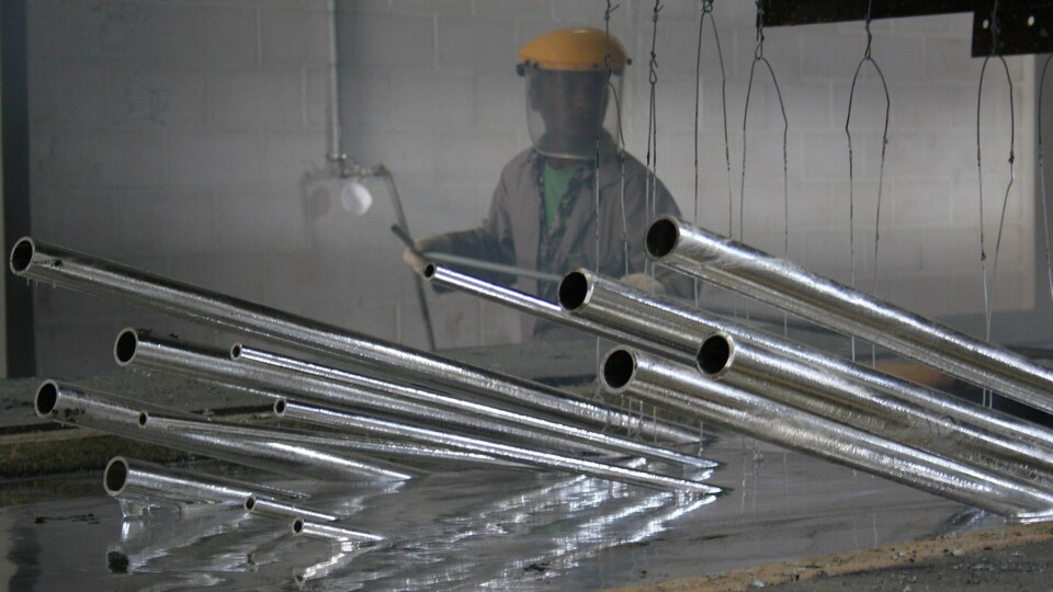 Des tuyaux semi submergés dans un bain de zinc.