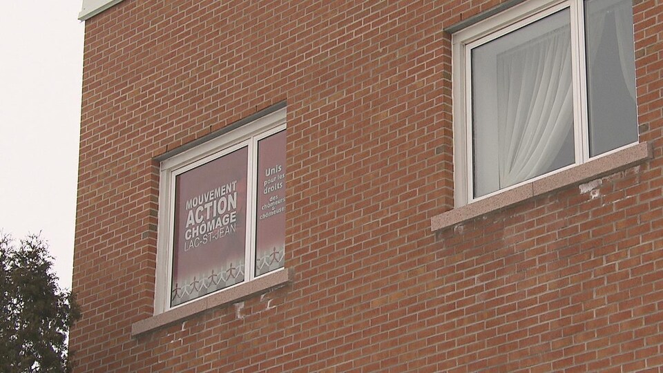Affiche du mouvement Action Chômage Lac-Saint-Jean dans la fenêtre des locaux.