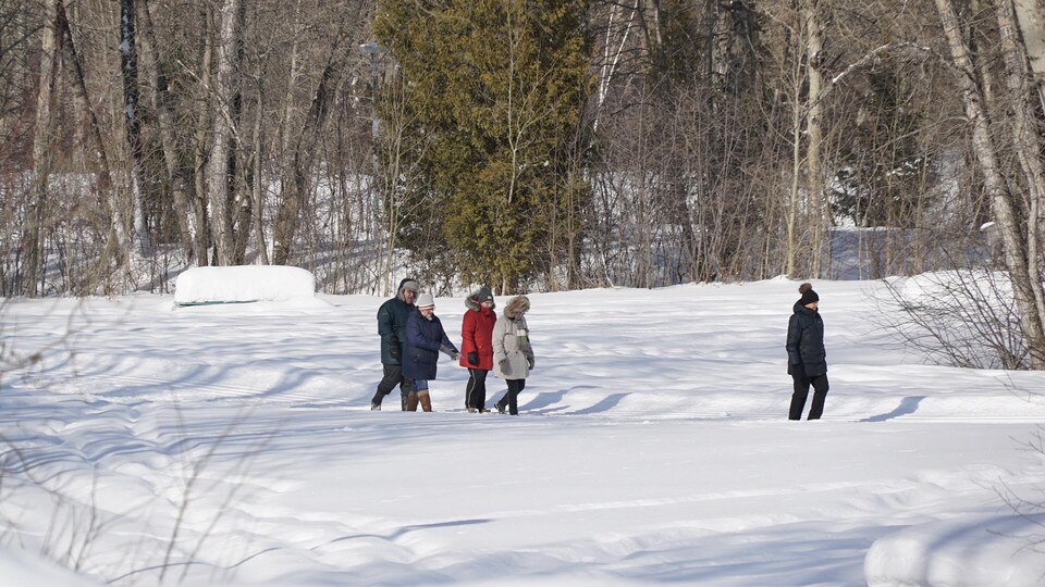 Des promeneurs dans un parc de Rimouski, en hiver.
