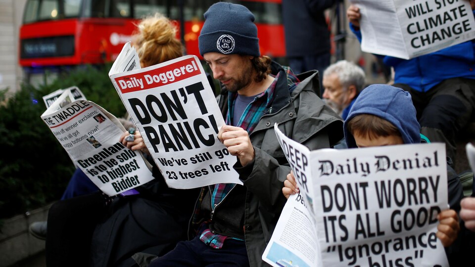 Des manifestants lisent de faux journaux satiriques à Londres, en Angleterre, le 14 octobre 2019.