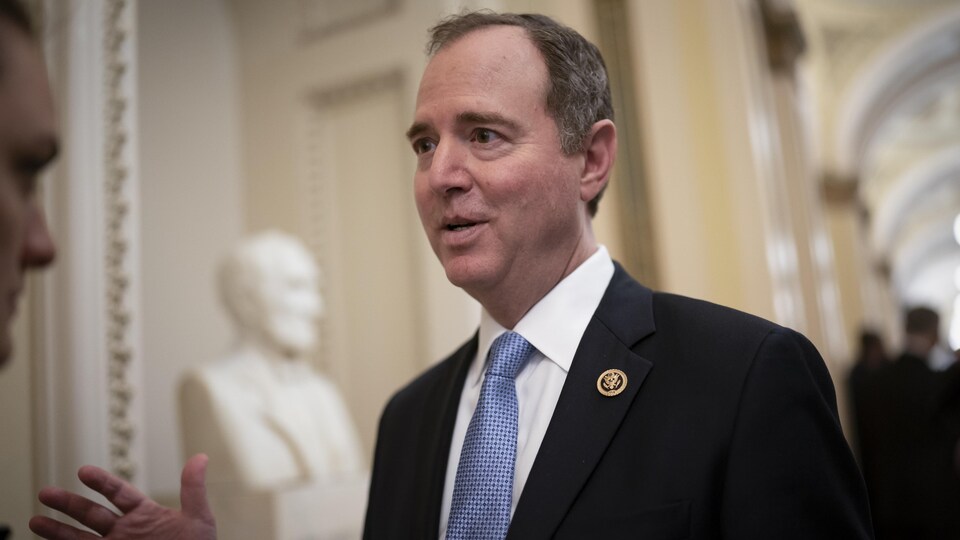 Adam Schiff speaks in front of a white marble statue. 