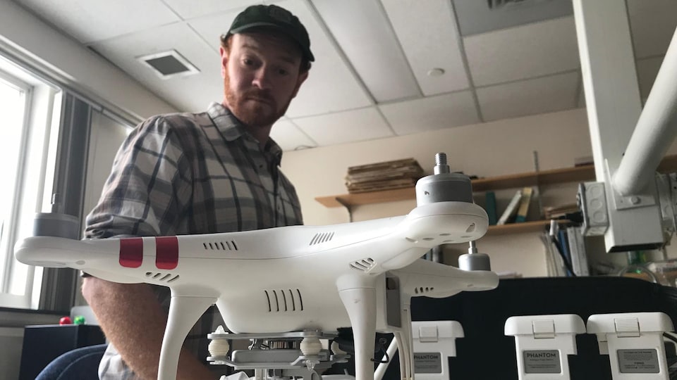 Adam Sprott regarde l'un des drones utilisés pour ses travaux de recherche.