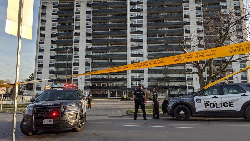 Deux véhicules de police et du ruban jaune.