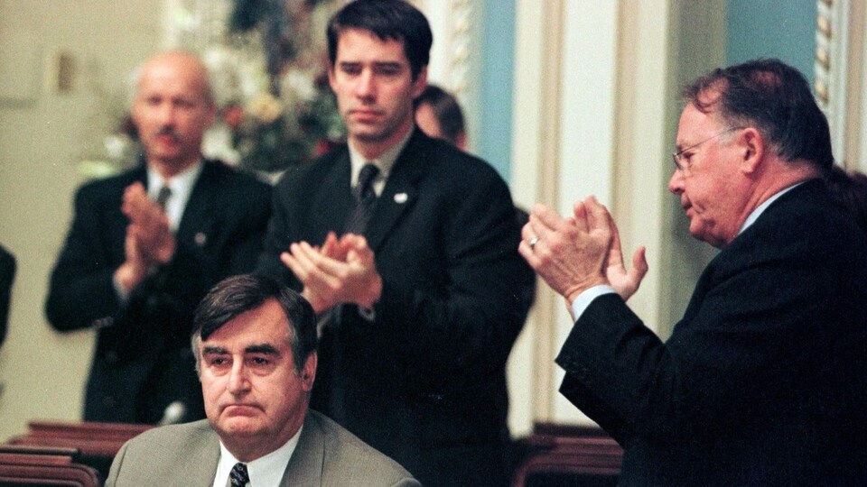 Les ministres péquistes Bernard Landry et André Boisclair applaudissent Lucien Bouchard à l'Assemblée nationale.