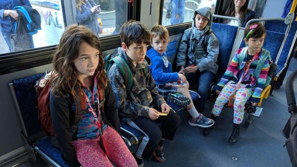 Cinq enfants assis dans un autobus.