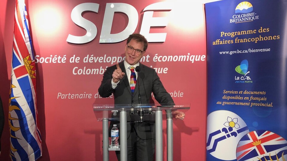 Adrian Dix derrière un lutrin qui sourit