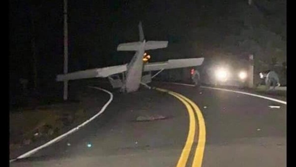 Un petit avion au milieu d'une route dans le noir.
