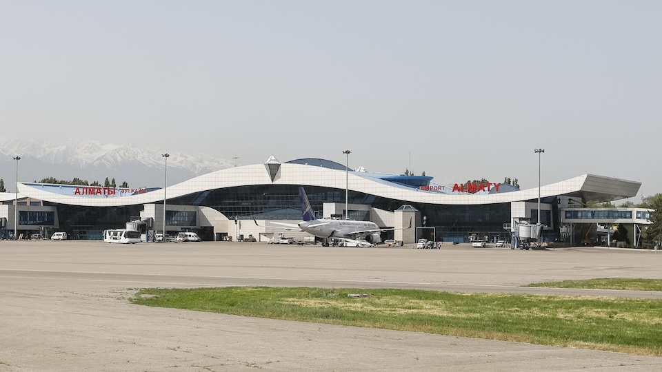 Le terminal de l'aéroport est situé devant des montagnes enneigées.