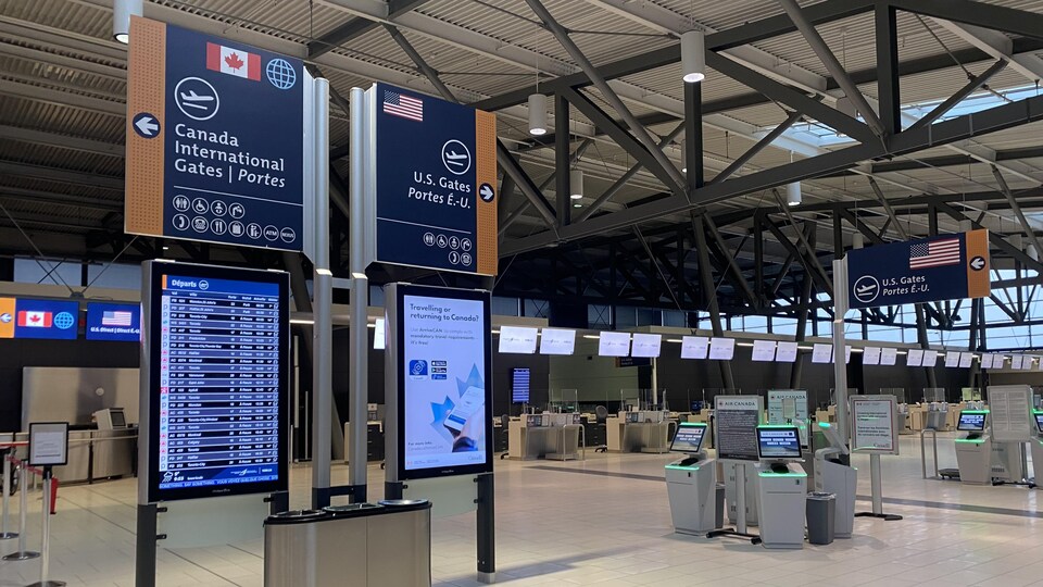 Des panneaux à l'intérieur d'un aéroport indiquant les départs.