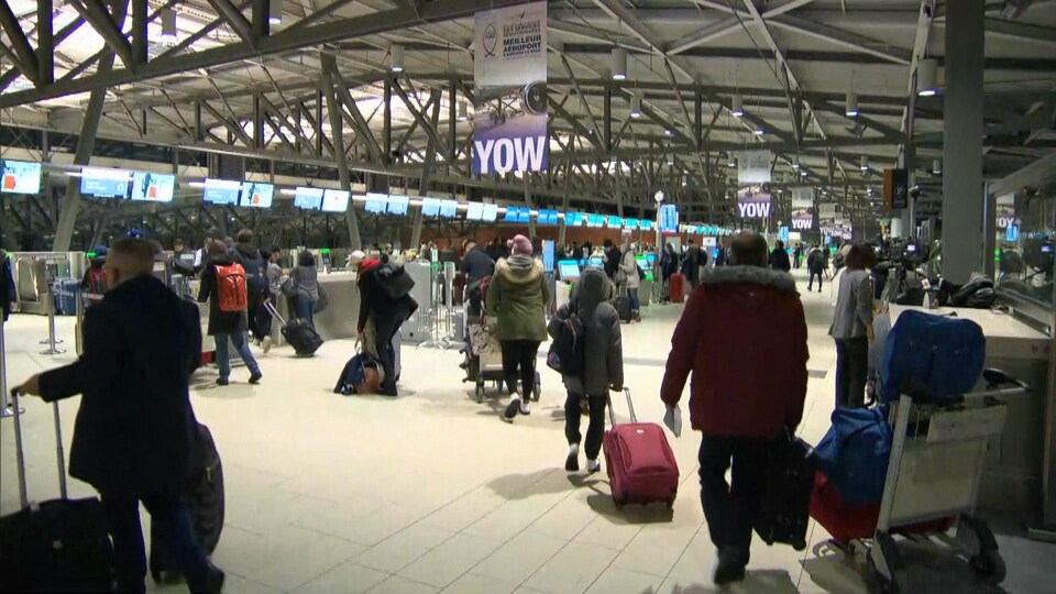 Le terminal de l'aéroport d'Ottawa est bondé de voyageurs.